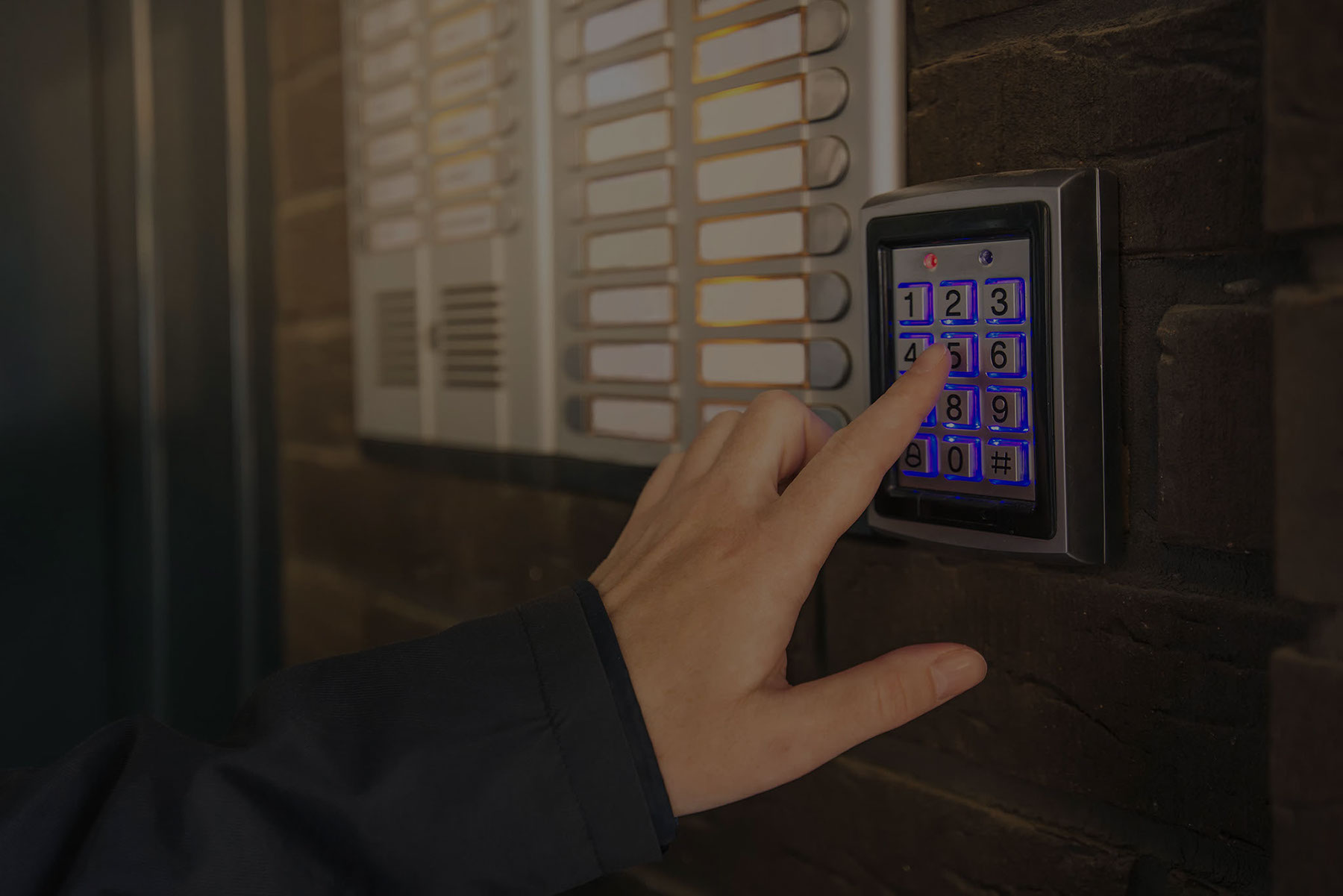 A finger pressing on an apartment doorway keypad